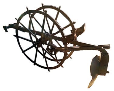 old tool with two spoked wheels on either side of a shaft with a flat…